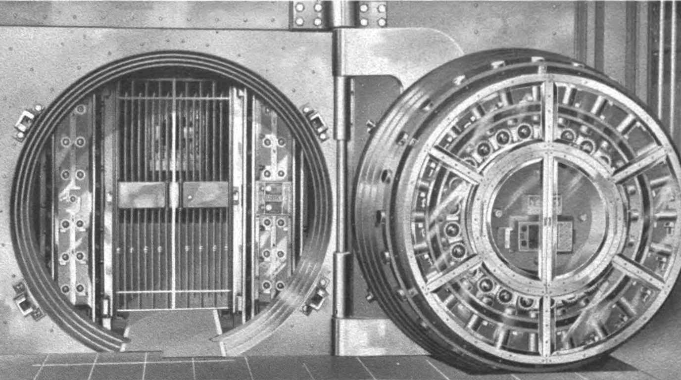 A 1908 photograph of a round steel bank-vault door standing open beside its barred inner gate.