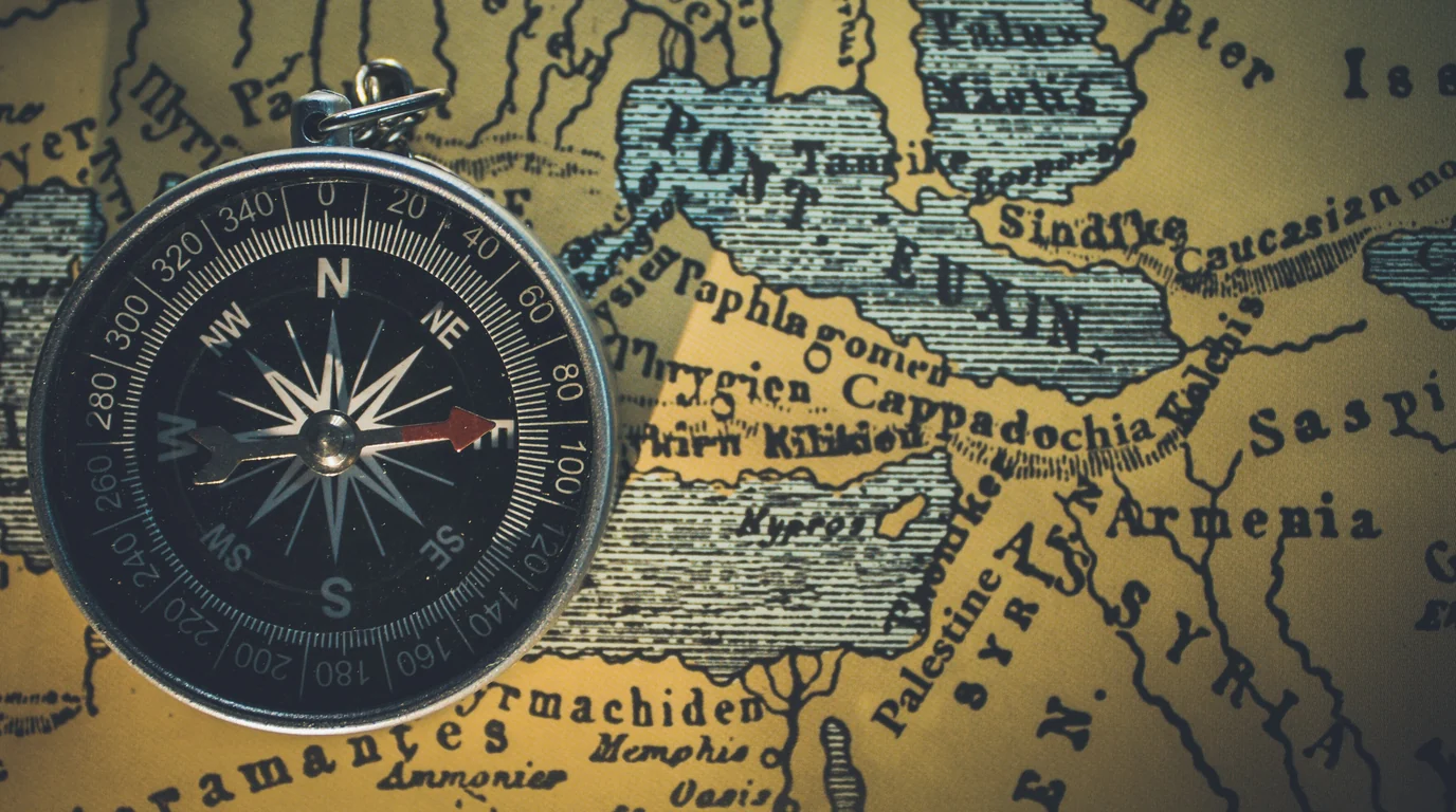 A pocket compass lying on an old printed map of the Black Sea region.