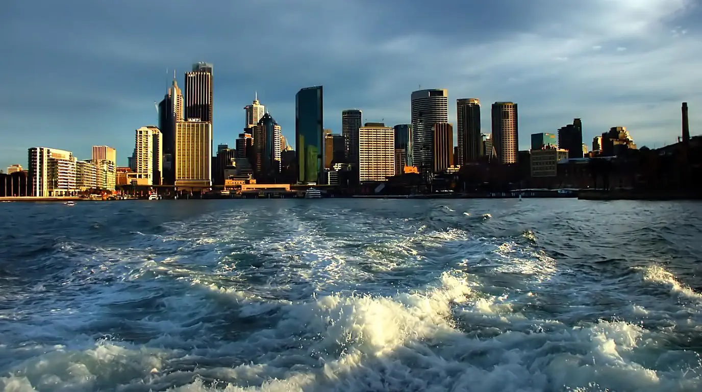 The Sydney city-centre skyline seen from the churned wake of a harbour ferry
