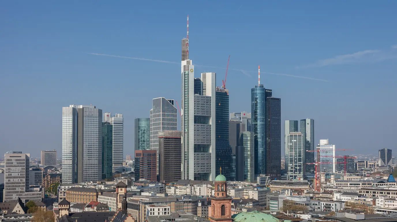 The Frankfurt am Main banking-district towers under a clear blue sky, older city buildings in front